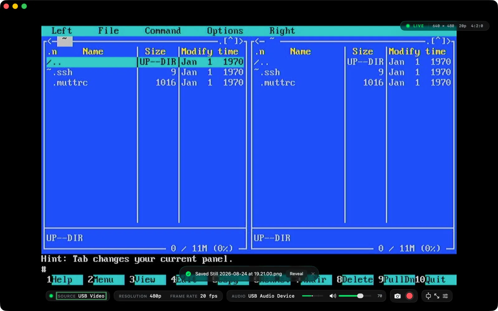 A capture card feeding a Midnight Commander session into the window. The status capsule reads LIVE, 640 by 480, 20p, 4:2:0; the control bar shows the source, resolution, frame rate, audio input and volume; and a notification reads Saved Still with the file name and a Reveal button.